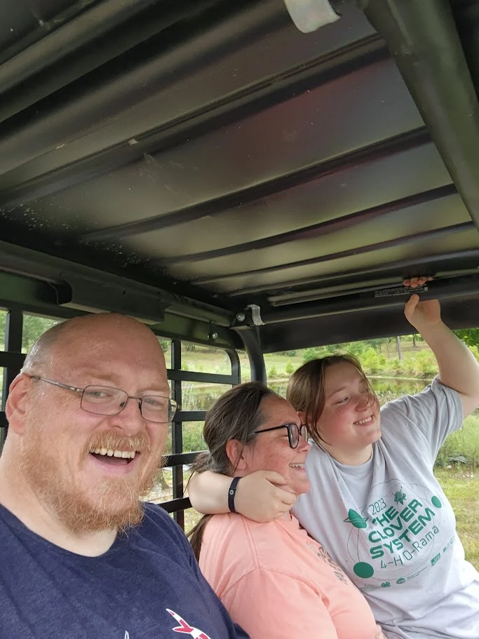 Three family members sharing a laugh on a ride around the farm